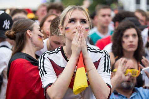 A woman watches the football match in the fan zone at the Brandenburg Tor during the quarter-final