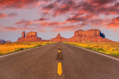 Sunset in the road with its yellow lines of Monument Valley, Utah
