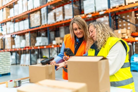 Women workers scanning parcels while preparing a deliver in a warehouse
