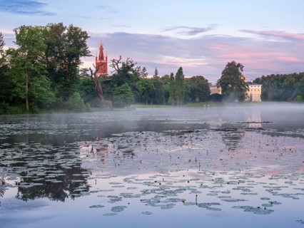 View over Lake Wörlitz to Wörlitz Castle and the Bible Tower of St Peter's Church in Wörlitz Park