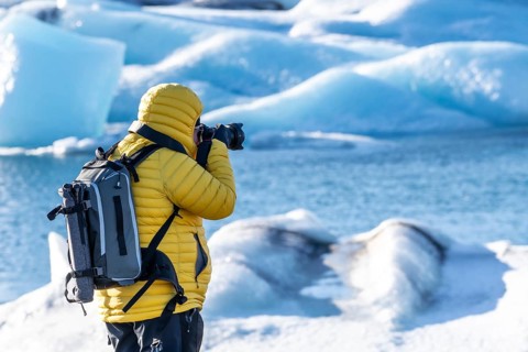A photographer photographing the floating icebergs in the Jokulsarlon glacier lagoon in Iceland.
