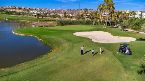 Aerial drone wide view of three people playing in a luxury golf course in summer