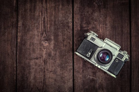 Photography concept background, old retro vintage camera on grunge wooden texture