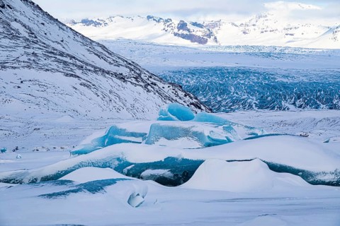 Snow-covered icebergs in the glacier lagoon Fjallsarlon, Breidamerkurjökull in the background,