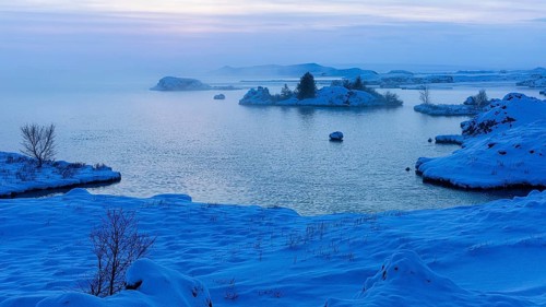 Snow-covered with bushes small island in Lake Myvatn, at blue hour, Kalfaströnd, Northern Iceland
