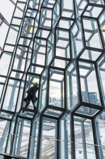 Window cleaners cleaning the glass facade of the Harpa Concert Hall and Congress Centre, interior