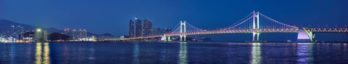 Panorama of Gwangan Bridge and skyscrapers illuminated in the night. Busan, South Korea, Asia