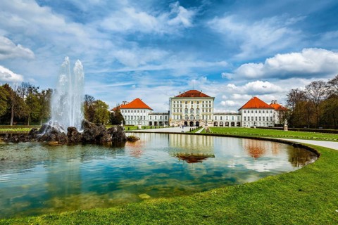 Fountain in Grand Parterre (Baroque garden) and the rear view of the Nymphenburg Palace. Munich,