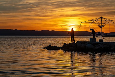 Anglers at sunset in Podgora, Croatia, Europe