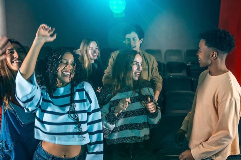 Cheerful young people dancing and having fun at a movie disco event, enjoying music and