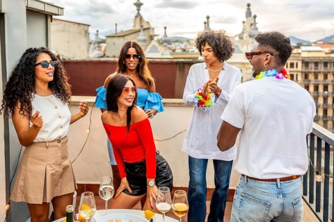 Woman dancing sensually latin music next to multi-ethnic friends in a rooftop party in the evening