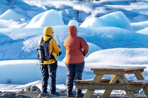 A couple looking at floating icebergs in the Jokulsarlon glacier lagoon in Iceland