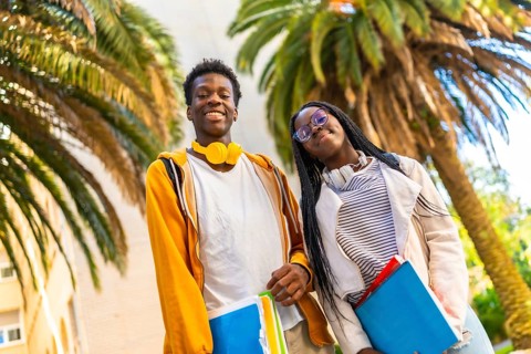 Low angle view portrait of two african american students smiling proud in the campus