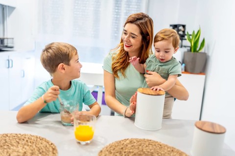 Caucasian family of a single mother with two kids having breakfast before going to school