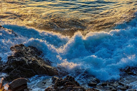 Waves foam over rocks during sunset in Salvador, Bahia, Salvador, Bahia, Brazil, South America