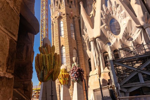 Colorful ceramic pinnacles and construction crane are visible at sagrada familia in barcelona, a