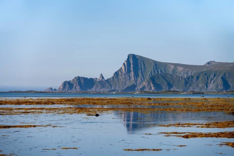 View of coastal landscape with reflection, steep coast with peak Måtind, Andøya island, Vesterålen,