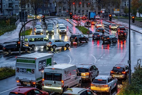 Rainy weather, road traffic, intersection, lights of vehicles on a wet road, traffic lights, tail