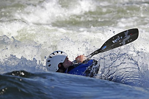 Kayaker kayaking in kayak in white water rapid
