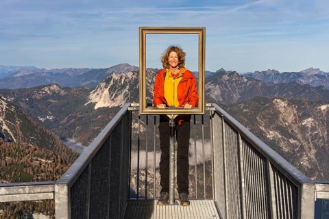 A hiker stands on the 5fingers viewpoint and looks through the picture frame. View from the