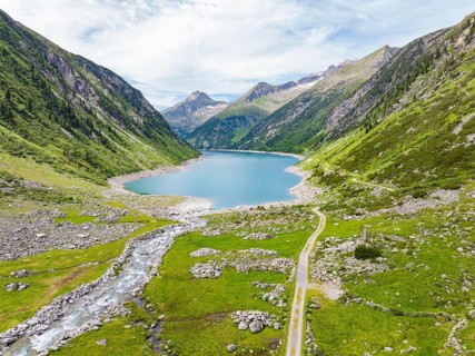 An idyllic mountain lake surrounded by high peaks and green meadows under a blue sky, Klein Tibet,