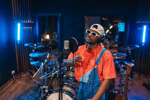 Talented musician singing and recording vocals for new song or album in professional music studio