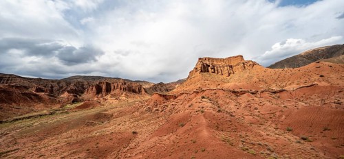 Eroded mountain landscape with sandstone cliffs, red and orange rock formations, Konorchek Canyon,