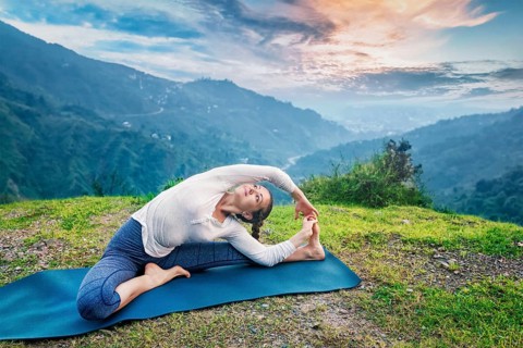 Yoga outdoors, young sporty fit woman doing Hatha Yoga asana parivritta janu sirsasana, Revolved