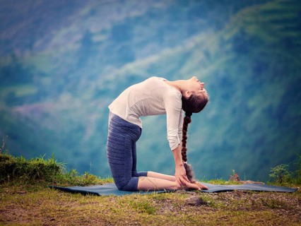 Yoga, outdoors young beautiful slender woman yoga instructor doing camel pose Ustrasana asana