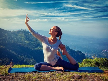 Yoga outdoors, young sporty fit woman doing stretching yoga asana Eka pada rajakapotasana,