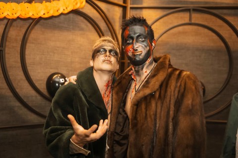 Friends in costumes at the halloween party with friends in a disco nightclub