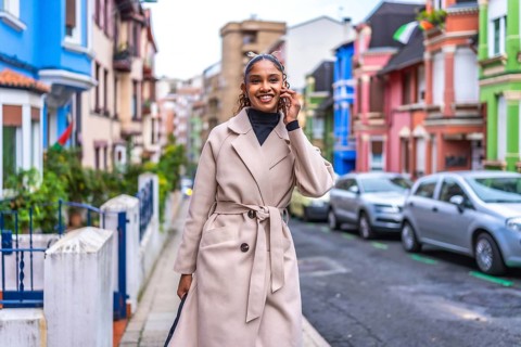 Stylish african american young and beauty woman talking to the mobile phone walking along the city