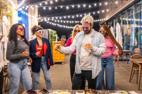 Cool man dancing with multiracial woman at night party in the roof of a bar at city
