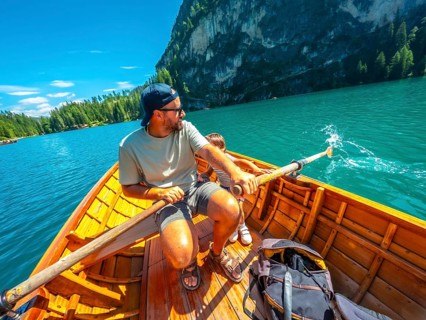 Tourists enjoying a sunny day rowing on the famous lake braies, surrounded by the stunning