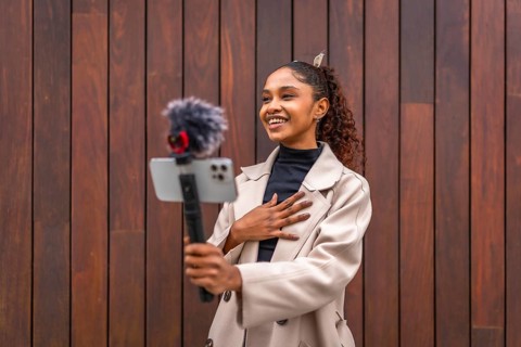 African american beauty woman vlogger smiling recording a new video blog in the city