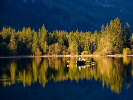 Angler in a rowing boat on the Hintersee in the first sunlight, Berchtesgaden National Park,