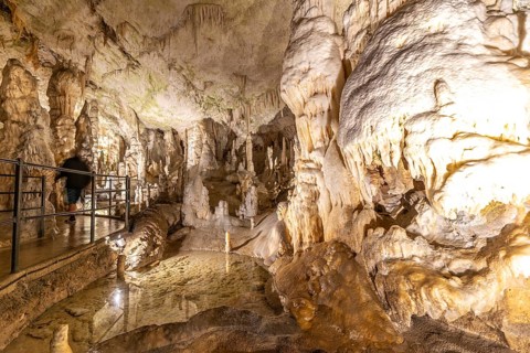 Tourists walking on a walkway marvel at the breathtaking stalactites and stalagmites formations