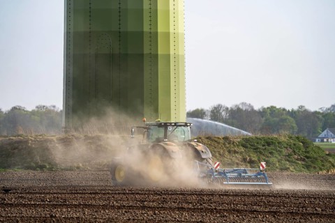 A tractor works a field, due to long dryness in spring, no rain for more than 4 weeks, the fields