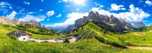 Breathtaking panorama of the dolomites in summer, showcasing lush green valleys, rugged peaks, and