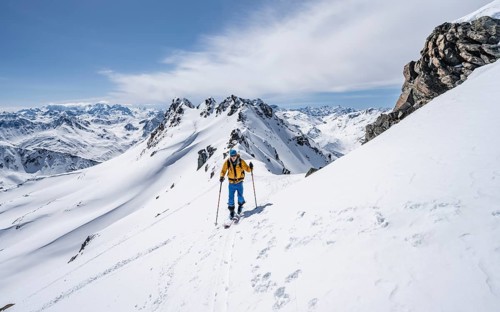 Ski tourer on a mountain ridge, mountain landscape with snow, mountain panorama with summit of the
