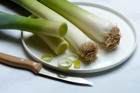 Leek, leek sticks on plate with knife, leek