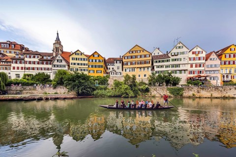 Neckarfront Tübingen with punt on the Neckar. Postcard motif with historic buildings and collegiate