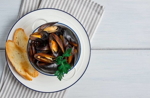 Fresh, Boiled mussels, Black Sea, with white bread, on a white wooden table, no people