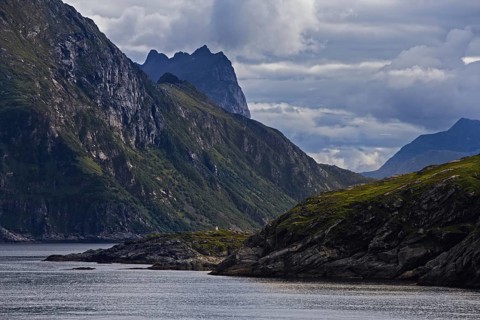 Dramatic coastline with green slopes and clouds over Bergen, Norway, Europe