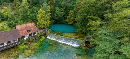 Blautopf Blaubeuren with industrial monument Hammerschmiede, source of the little river Blau in a