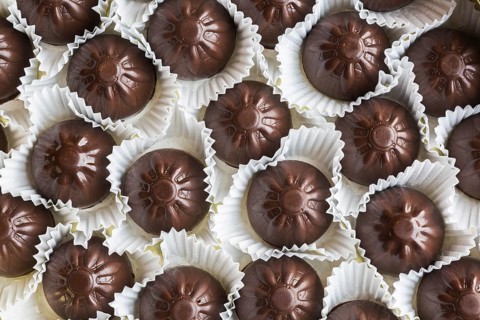Top view and close-up of hand made fine milk chocolates in opened chocolate box, Studio