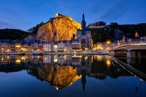 Night view of Dinant town, Collegiate Church of Notre Dame de Dinant over River Meuse and Pont