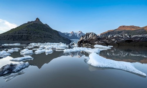 Reflection in the Svínafellslon glacier lagoon with ice floes, Svínasfellsjökull glacier tongue,