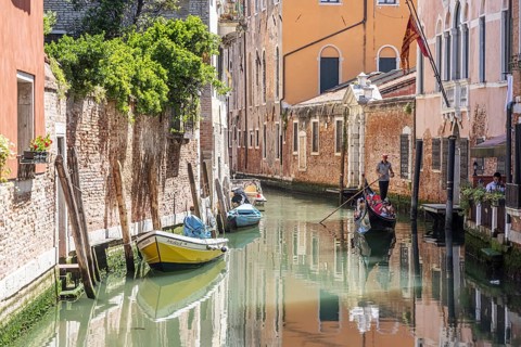 Venetian gondola with gondolier travelling on the canals of Venice, Venice, Italy, Europe
