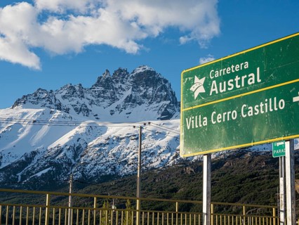 Signpost on road Carretera Austral at Villa Cerro Castillo, snowcapped Mt .Cerro Castillo,